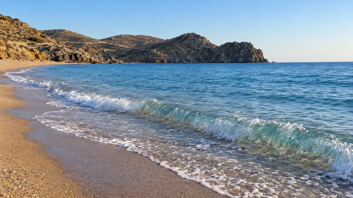 Waves on a golden beach below rocky headlands at Calblanque